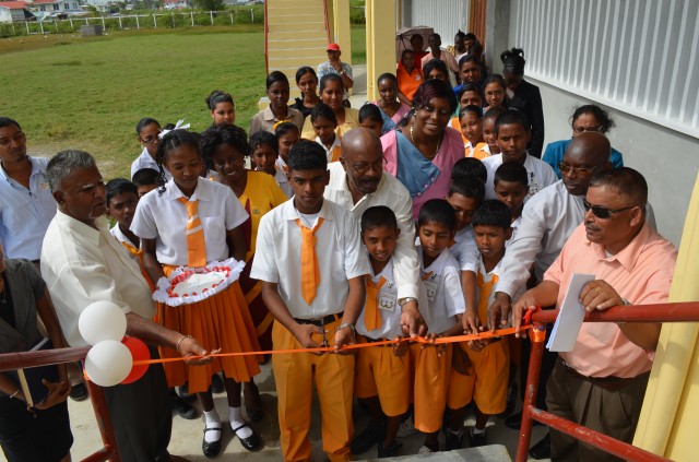 Minister of Local Government and Regional Development Norman Whittaker assists students of the Woodley Park Secondary School to commission the new department
